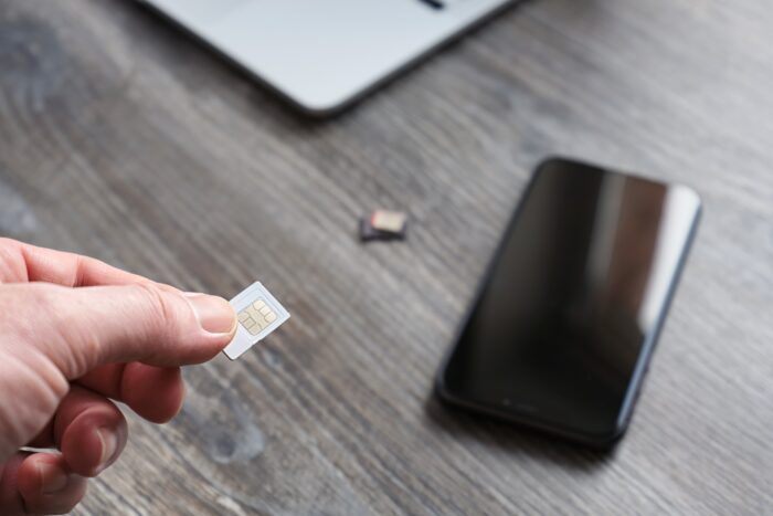 Vodafone Faces £120M Franchise Lawsuit: Lessons on Good Faith, Contracts and Business Risk 1 Male,Hand,Holding,A,Sim,Card,For,A,Smartphone,,Against